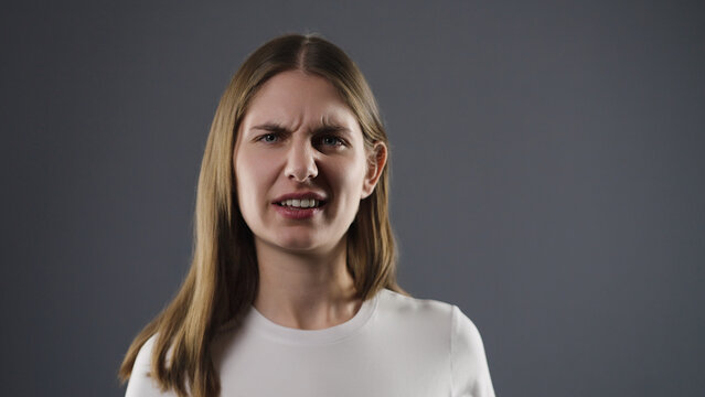 Young woman frowning with a negative facial expression, indicating displeasure or aversion