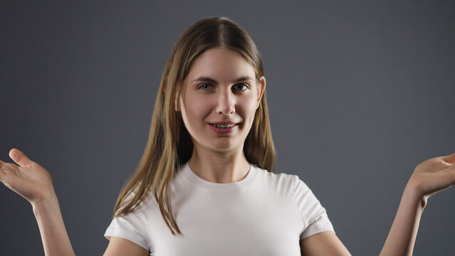 Young woman shrugging, expressing confusion and uncertainty