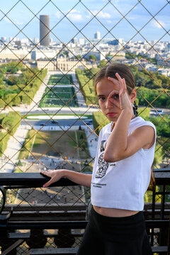 Young girl poses playfully near a city view