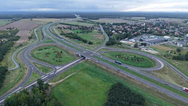 Aerial highway interchange with loop ramps and surrounding fields