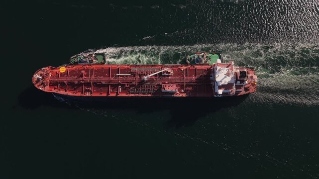 Fuel tanker arriving at Halifax Port from the Atlantic Ocean, viewed from above as two tugboats escort the vessel through the harbor toward the petroleum terminal in Nova Scotia.