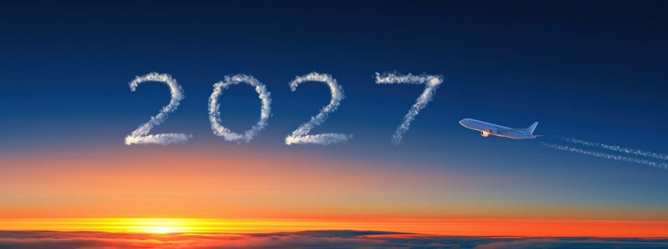 2027 year airplane flying through a sunset sky creating vapor trails for future travel and flight