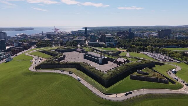 Summer drone view of Halifax city and harbour, Canada, showcasing the urban skyline along the waterfront and busy maritime traffic with ships and boats crossing the blue coastal waters.