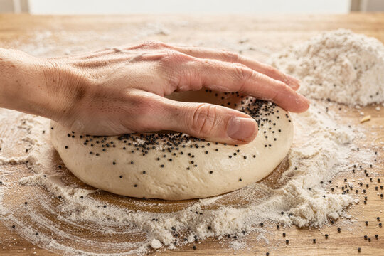 Hand Kneading Poppy Seed Bread Dough on Floured Table