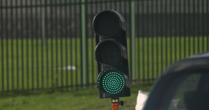 Green traffic signal go light motor car traffic passing by