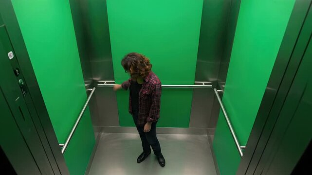 Woman in elevator with green walls looking up, cinematic shot