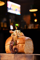 Close-up of an octopus tentacle  shrimp and octopus seafood sandwich on a wooden board against a black background. © mario