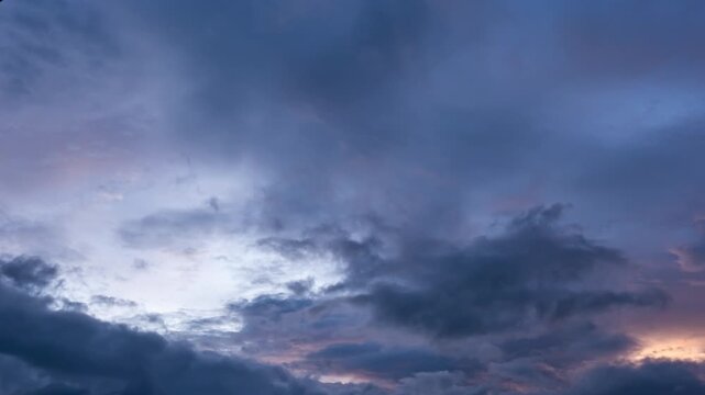 Ominous dark thunderclouds moving fast across the sky, impending rain storm time-lapse.