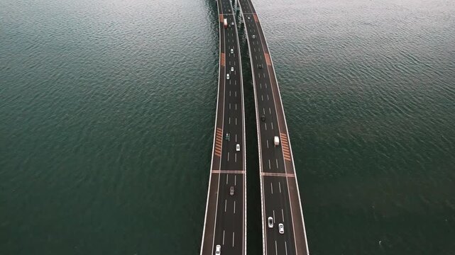 Aerial view of two parallel bridges over water with light traffic