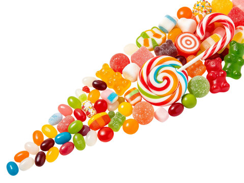 Colorful assortment of sweet candies lollipops gummy bears jelly beans and marshmallows arranged diagonally