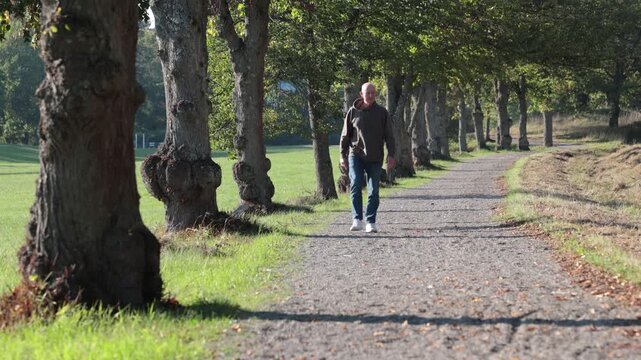 Stockholm, Sweden A man walks on a wooded path in the autumn in the public Djurgarden park.  