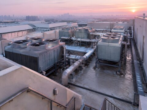 Rooftop chiller plant of a mall at dawn with large galvanised casings round fan cowls and insulated pipes
