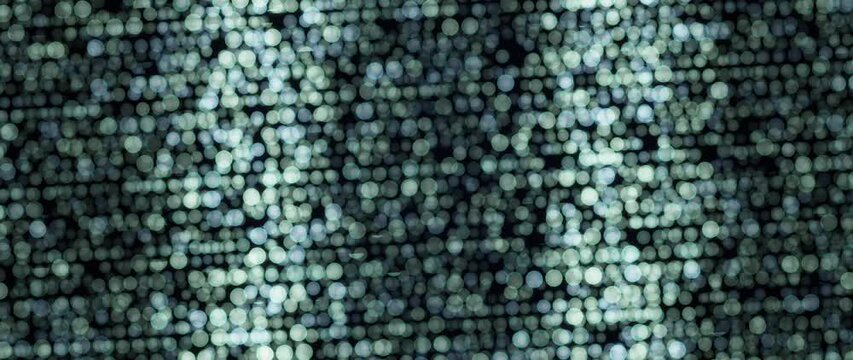 Abstract light dots shimmer and shift across a dark teal patterned background
