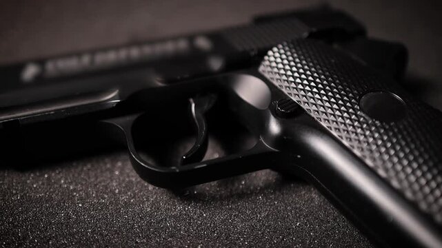 Close Up of Black Textured Airsoft Handgun on Dark Background