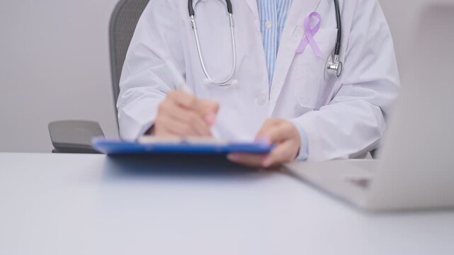 doctor using laptop and report notes on notebook. light purple ribbon for concept of All cancer, April Esophageal Cancer, November gastric and Stomach cancer,  Hodgkin Lymphoma and World cancer day