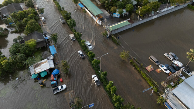 An elevated view of a flooded road with vehicles driving through the water.	