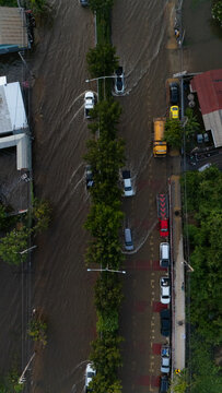 An elevated view of a flooded road with vehicles driving through the water.	
