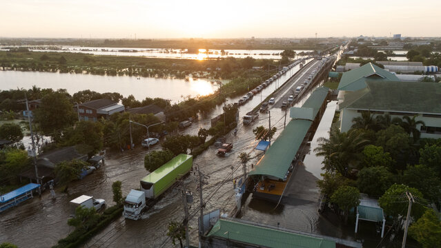 An elevated view of a flooded road with vehicles driving through the water.	