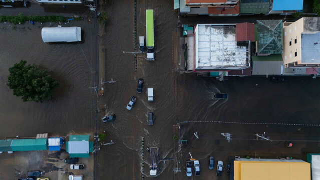 An elevated view of a flooded road with vehicles driving through the water.	