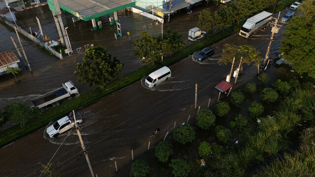 An elevated view of a flooded road with vehicles driving through the water.	