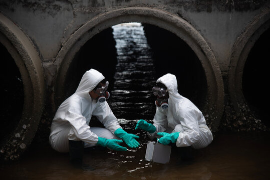 Scientist wearing protective uniform and glove under working water analysis and water quality by get waste water to check case in laboratory is environment pollution problem concept.