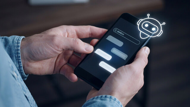 Person using chatbot application on smartphone screen with message bubbles and robot icon during daytime
