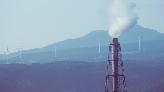 Industrial factory plant and steel mill with white smoke emitting from chimney in Muroran, Hokkaido, Japan. Cinematic heavy industry infrastructure background, fixed 4K video.