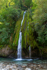 Kaghu Waterfall, located in the Samegrelo region of Georgia, A vibrant waterfall cascades down a mossy stone © k_samurkas