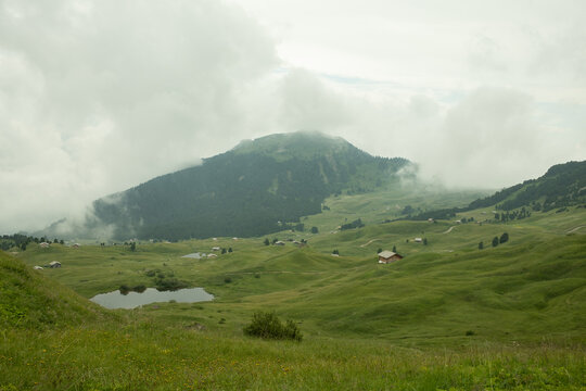 beautiful mountain landscape with small pond and misty clouds