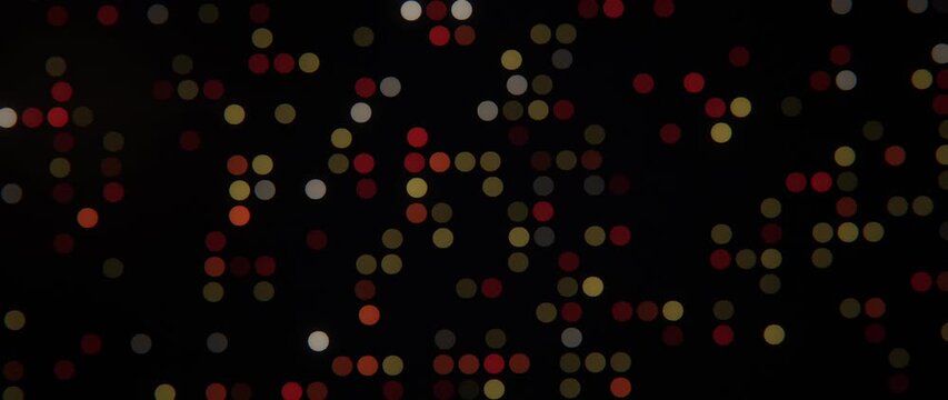 Colored circular lights softly flicker in a scattered pattern against a black background