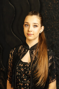 Teen Girl Posing With Finished Makeup Against Dark Background