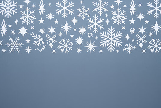 White snowflakes and stars on blue gradient winter background