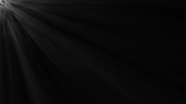 Bright light rays shining from top corner on black background 