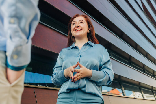Female manager or employee talking with business colleague, stylish suit, outdoor portrait