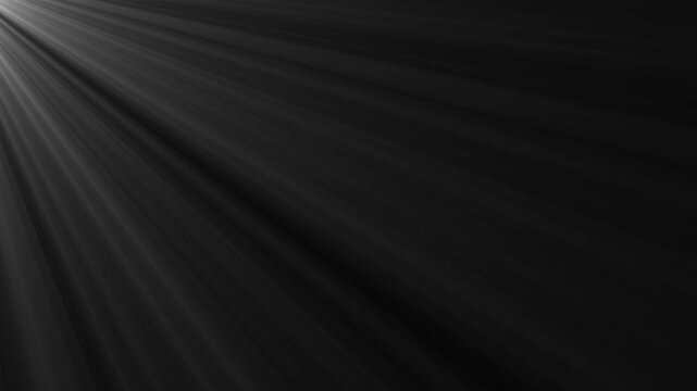 Bright light rays shining from top corner on black background 