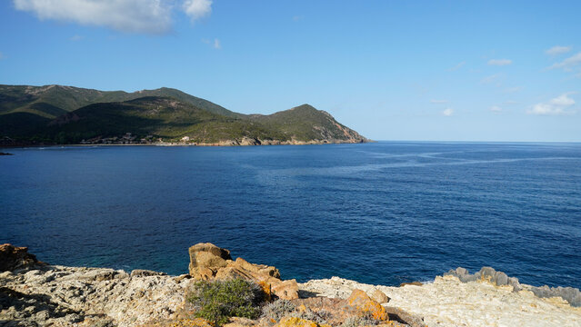 Il golfo di Galeria nella costa occidentale della Corsica con la torre genovese detta Calcinaggia e la spiaggia di sabbia nera della Ricciniccia sulla foce del fiume Fango