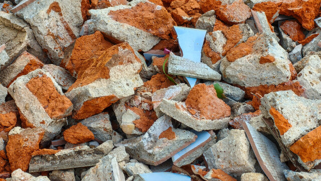 Broken bricks and ceramic tile fragments in a pile of construction rubble.