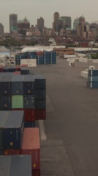 Vertical video: Close up aerial dolly view of the top of containers at New York City container terminal and port, New York City, United States in 2019