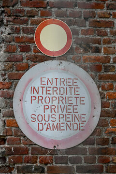 deux vieux panneaux ronds d'interdiction de circuler et de p&eacute;n&eacute;trer dans une propri&eacute;t&eacute; priv&eacute;e sont fix&eacute;s sur un mur en briques rouges et brunes. 