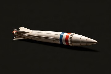 Fototapeta premium Missile model laying on a dark surface, symbolizing conflict and defense