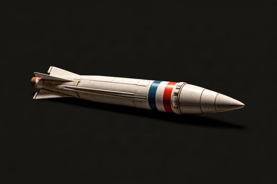 Missile model laying on a dark surface, symbolizing conflict and defense