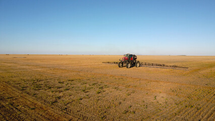 Aerial View of Self-Propelled Agricultural Sprayer Treating Stubble Field © Andrey