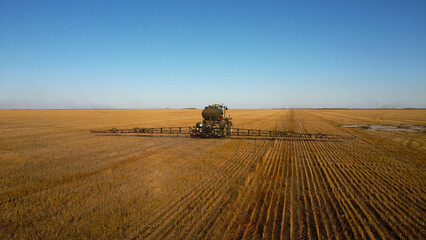 Aerial View of Self-Propelled Agricultural Sprayer Treating Stubble Field © Andrey