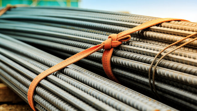 Bundle of steel rebar tied with orange strap on site
