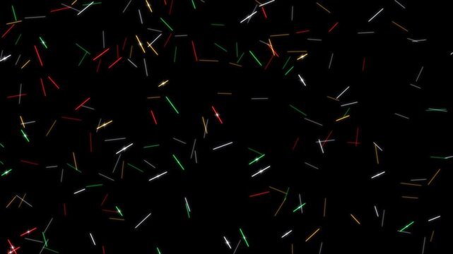 Short tinsel strands in silver, gold, red and green spinning and glinting as they fall on black background