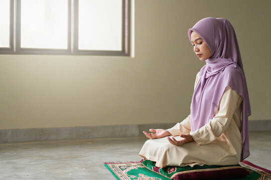 Young woman in pastel hijab praying quietly on a prayer rug