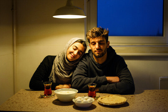 Young couple sharing a pre-dawn suhoor meal at a kitchen counter