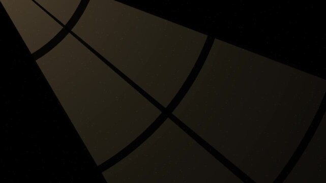 Warm sunlight rays shining through a window frame casting soft shafts of light with floating dust on black