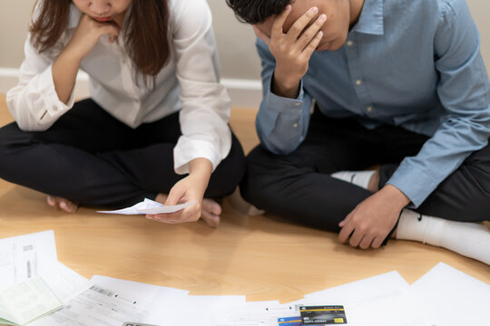 Stressed and headache asian couple with large bills or invoices no money to pay to expenses and business problem. shortage, Financial problems, mortgage, loan, bankruptcy, bankrupt, poor
