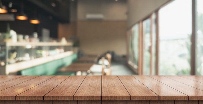 Empty wooden table top with lights bokeh on blur restaurant background.	
